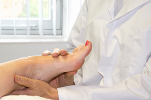 A Podiatrist Holding A Person’s Foot | Plantar Fasciitis